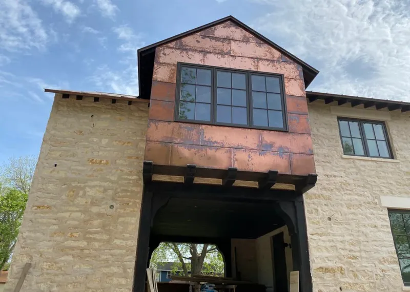 Copper metal panel facade on a stone building for Roof Repair in Atascocita
