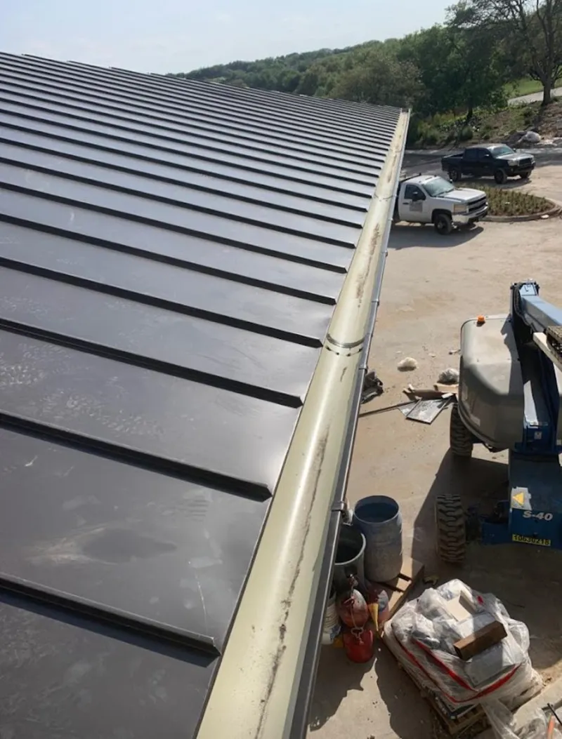 Standing seam panel and gutter detail on a metal roofing jobsite in Atascocita